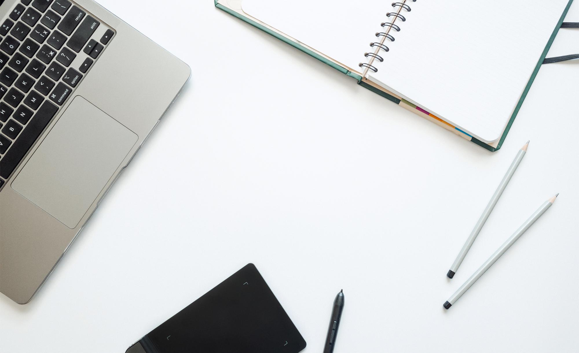 Minimal workspace mit Laptop und Notizen